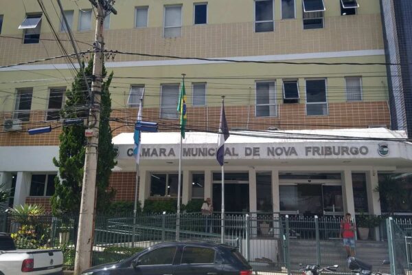 Fachada da Câmara Municipal de Nova Friburgo, com bandeiras hasteadas.