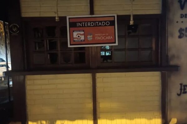 Fachada de quiosque interditado após incêndio em Itaocara, RJ. Placa com aviso: Interditado.