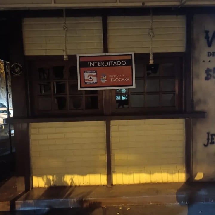 Fachada de quiosque interditado após incêndio em Itaocara, RJ. Placa com aviso: Interditado.