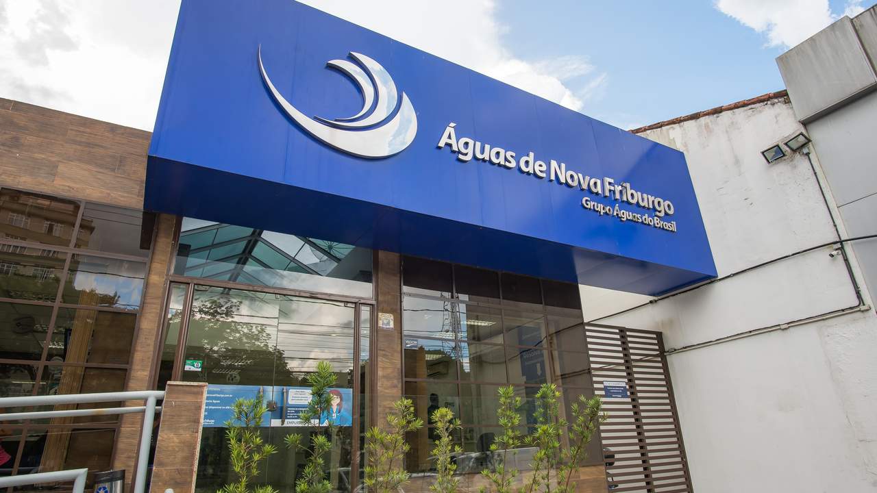 Fachada de uma agência da Águas de Nova Friburgo, empresa do Grupo Águas do Brasil, com a logo da empresa e a frase "Mês das Mães".