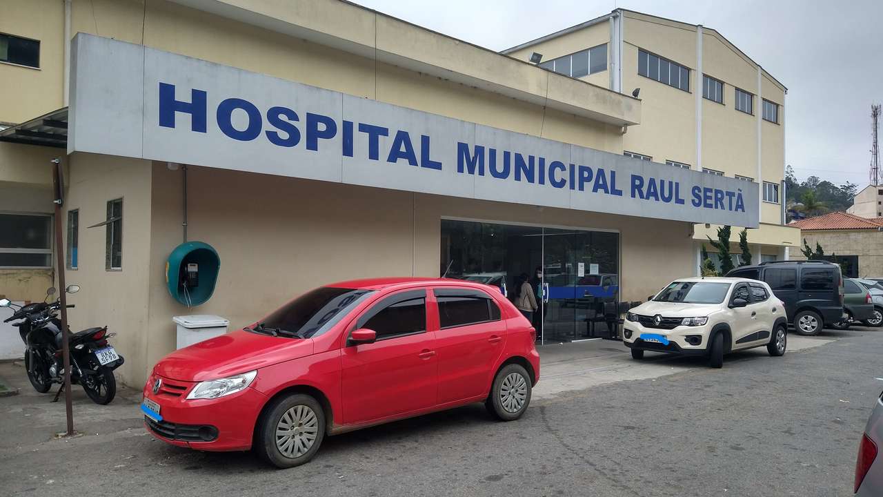 Fachada do Hospital Municipal Raul Sertã, com carros estacionados e letreiro.