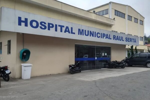 Fachada do Hospital Municipal Raul Sertã, com placa e veículos estacionados.