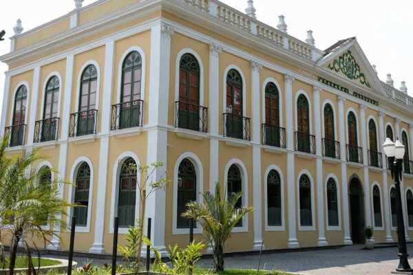 Fachada do Palácio Barão de Guapi em Barra Mansa, um prédio histórico com janelas em arco e detalhes arquitetônicos.
