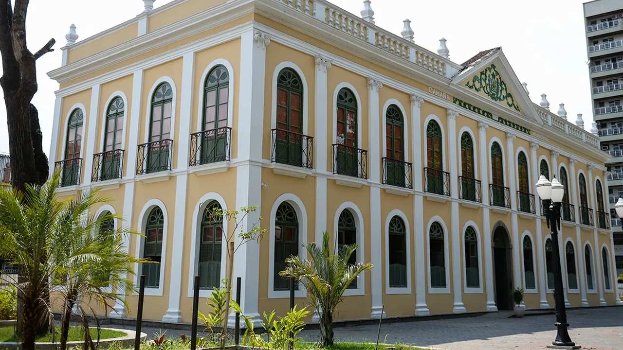 Fachada do Palácio Barão de Guapi em Barra Mansa, um prédio histórico com janelas em arco e detalhes arquitetônicos.