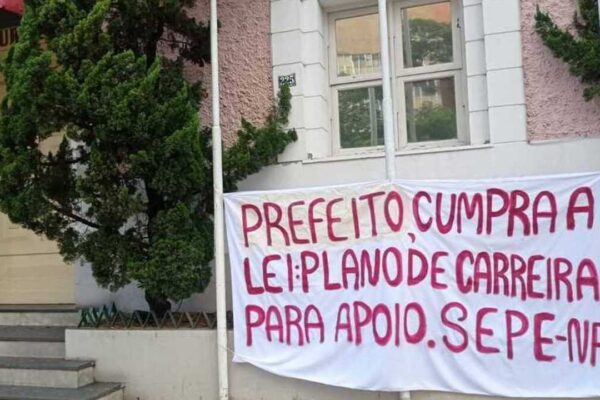 Faixa com mensagem de protesto de professores em frente à prefeitura.