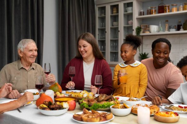 Família reunida à mesa para refeição festiva, celebrando em casa.