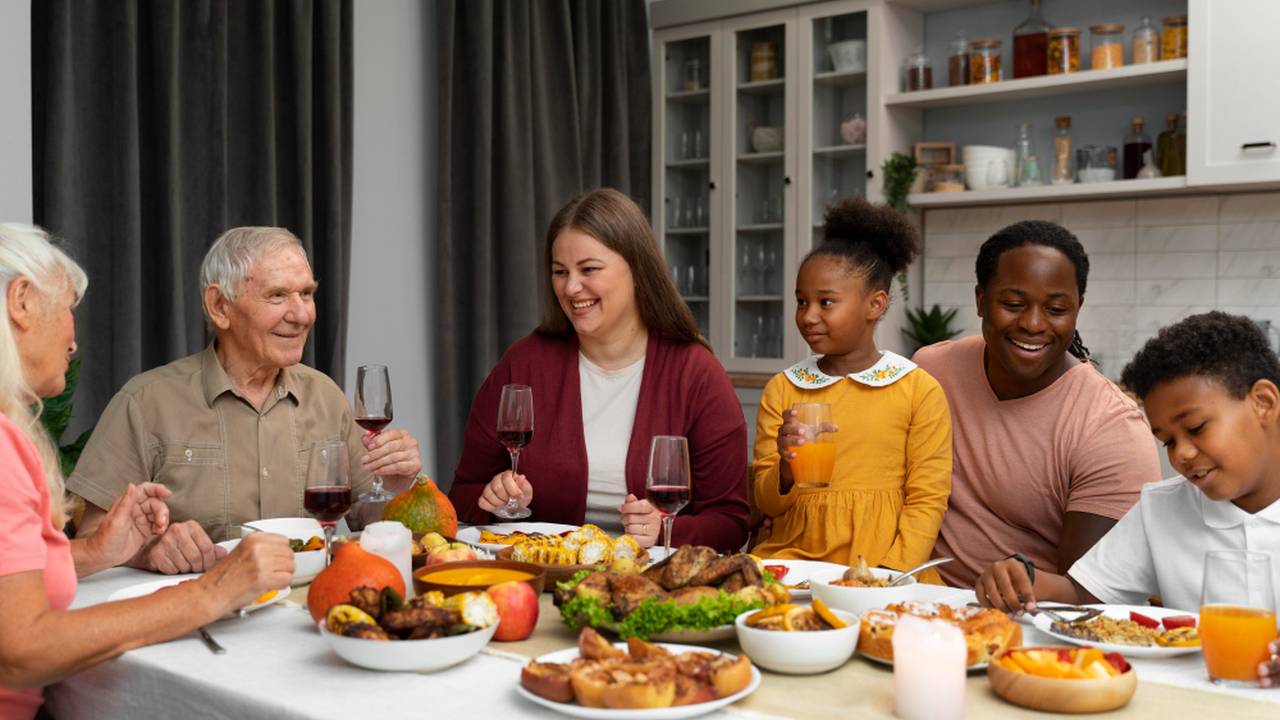 Família reunida à mesa para refeição festiva, celebrando em casa.