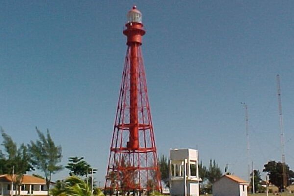Farol de São Thomé, estrutura vermelha similar à Torre Eiffel, em dia ensolarado.