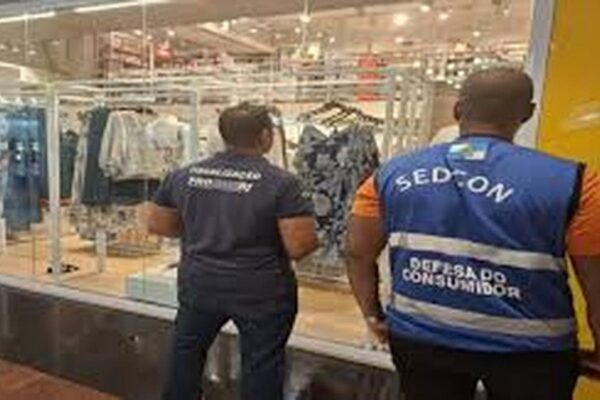 Fiscais do Procon em ação em frente a uma loja de roupas em shopping