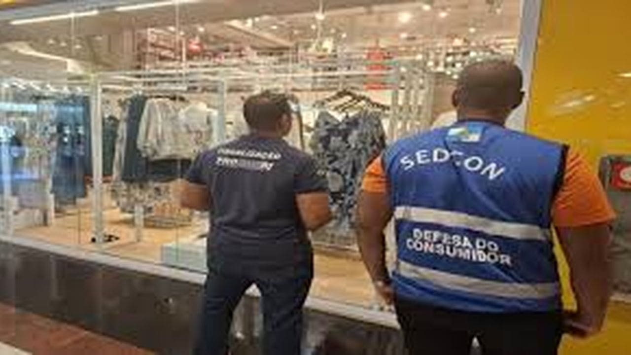 Fiscais do Procon em ação em frente a uma loja de roupas em shopping