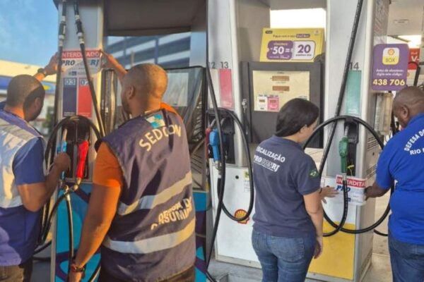 Fiscais interditam postos de gasolina no Rio de Janeiro, com selos de interdição nas bombas.