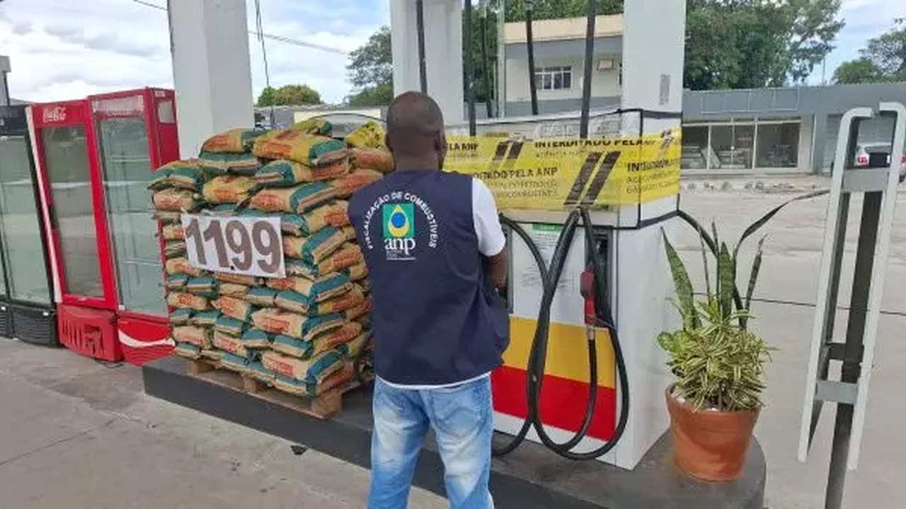 Fiscalização da ANP em posto de combustível, com produtos empilhados e bomba interditada.
