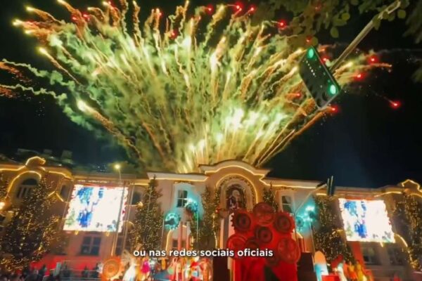 Fogos de artifício em show de Natal em Nova Friburgo com prédios iluminados e árvores decoradas.