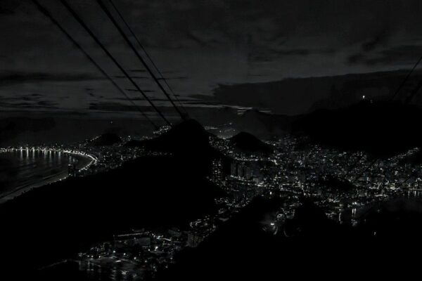 Foto noturna em preto e branco do Rio de Janeiro sem luz, mostrando a cidade escura.