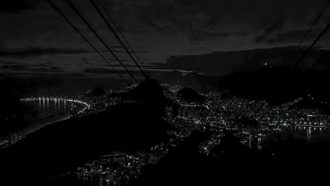 Foto noturna em preto e branco do Rio de Janeiro sem luz, mostrando a cidade escura.