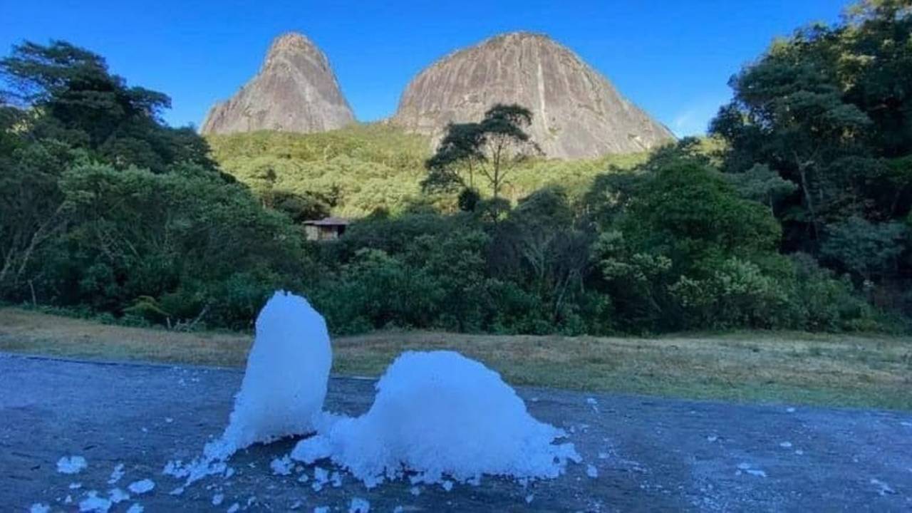 Geada no Parque Estadual Três Picos, mostrando montanhas e vegetação.