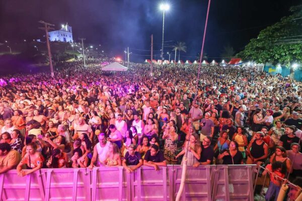 Grande público reunido em festival de verão em Saquarema, Brasil, à noite.