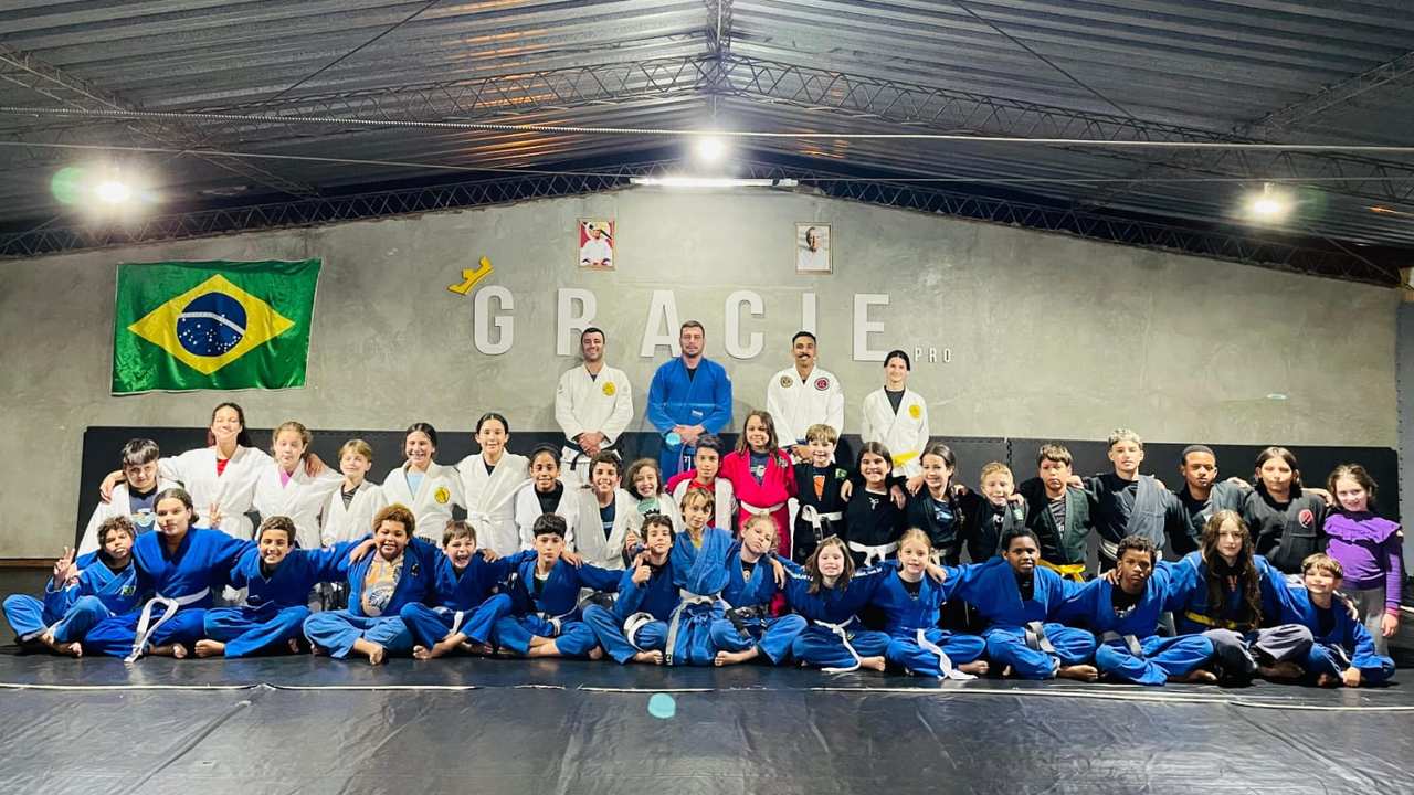 Grupo de Jiu-Jitsu com faixa preta e bandeira do Brasil