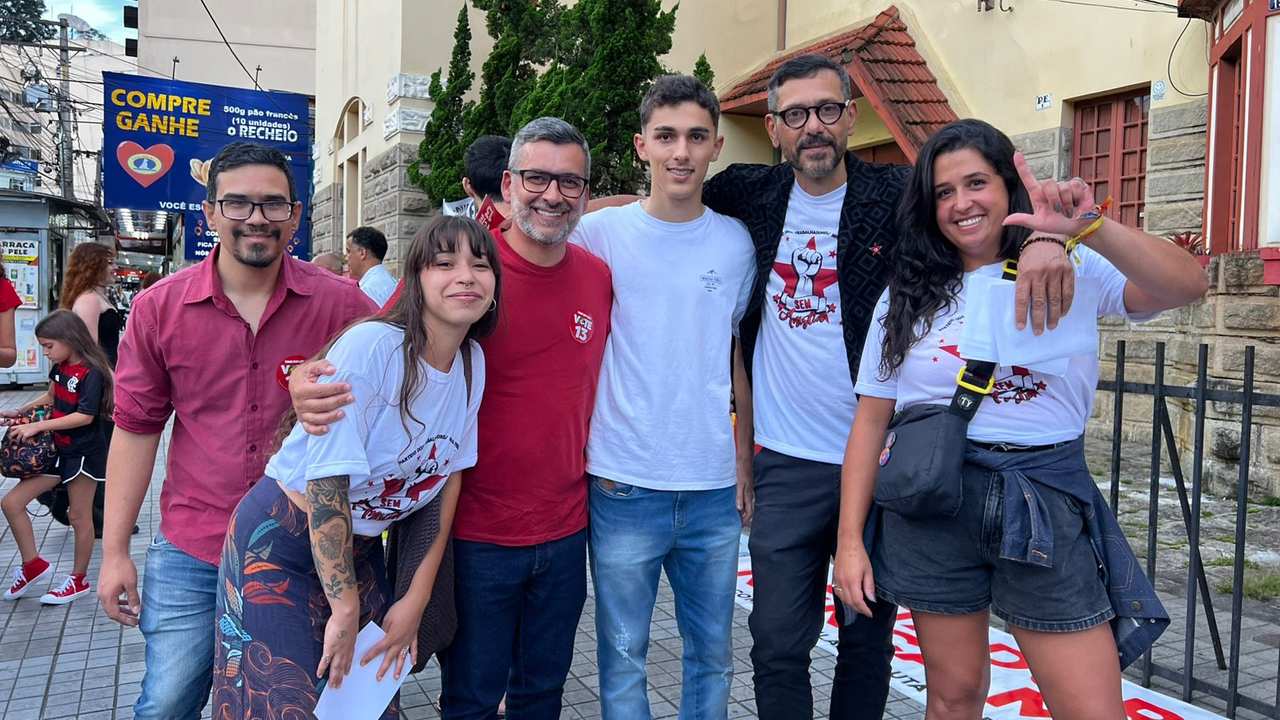 Grupo de pessoas em manifestação em Nova Friburgo, com camisetas e bandeiras.