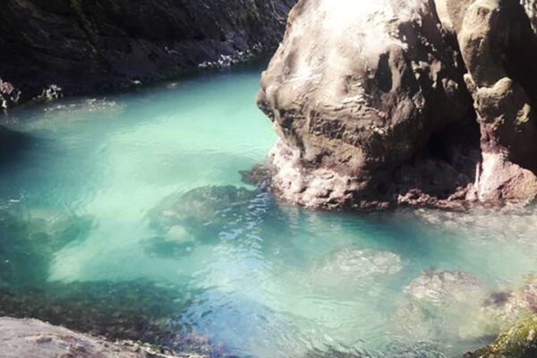 Gruta Ponta Negra em Maricá com água azul turquesa e rochas.
