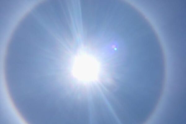 Halo solar em Nova Friburgo, com o sol brilhando no centro e um arco-íris circular.