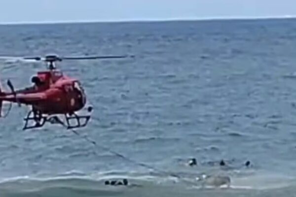 Helicóptero de resgate sobrevoa o mar com vítimas na água, em Itaipuaçu, Maricá.