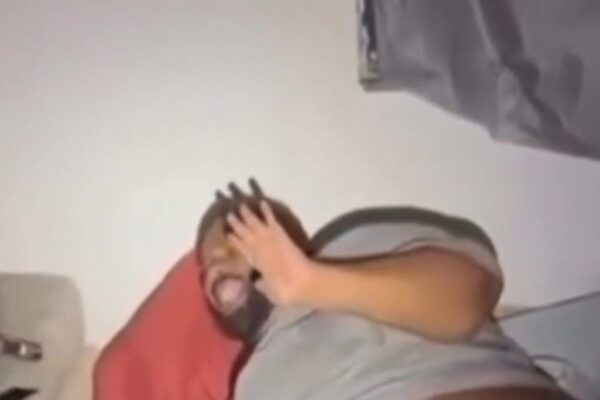 Homem com as mãos no rosto em situação de pânico, possivelmente durante uma prisão.