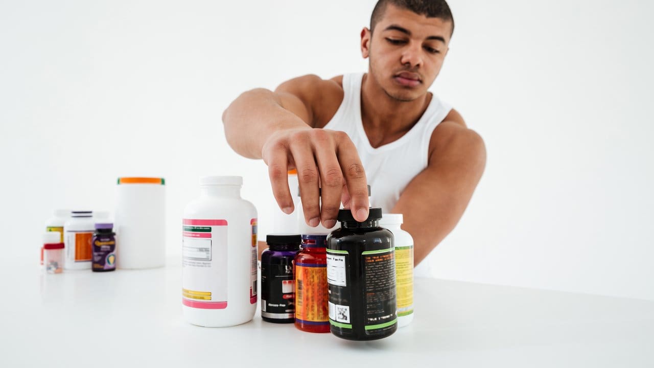 Homem selecionando suplementos nutricionais.