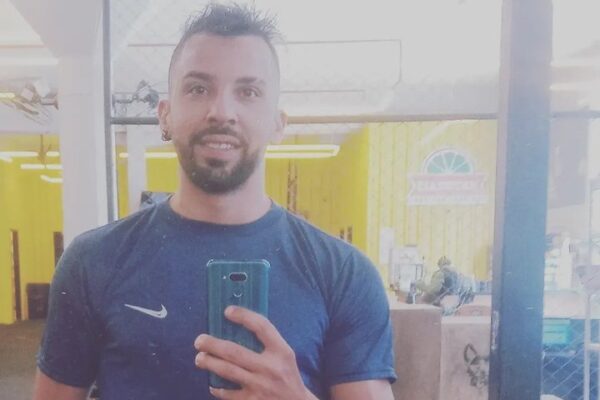Homem sorrindo tira selfie em espelho, potencial Derick Schuenck Combat.