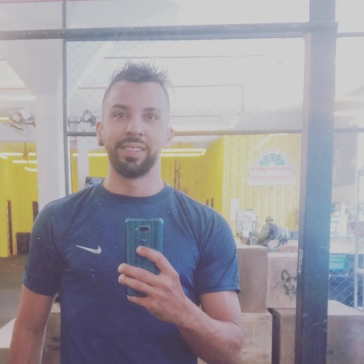 Homem sorrindo tira selfie em espelho, potencial Derick Schuenck Combat.
