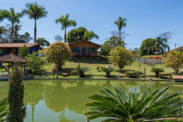 Hotel em Bom Jardim, Rio de Janeiro, com lago e vegetação exuberante, em dia ensolarado.