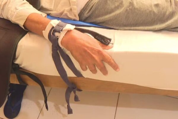 Idosa amarrada em asilo no Catumbi, Rio de Janeiro. Mãos presas na cama.