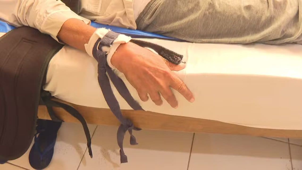 Idosa amarrada em asilo no Catumbi, Rio de Janeiro. Mãos presas na cama.