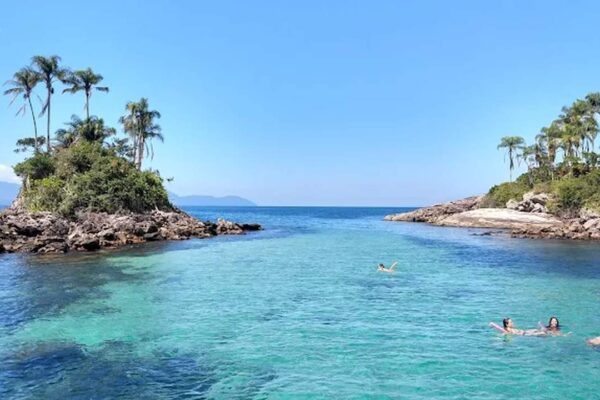 Ilhas Botinas com mar azul turquesa e pessoas nadando, foto de Vera Bordignon