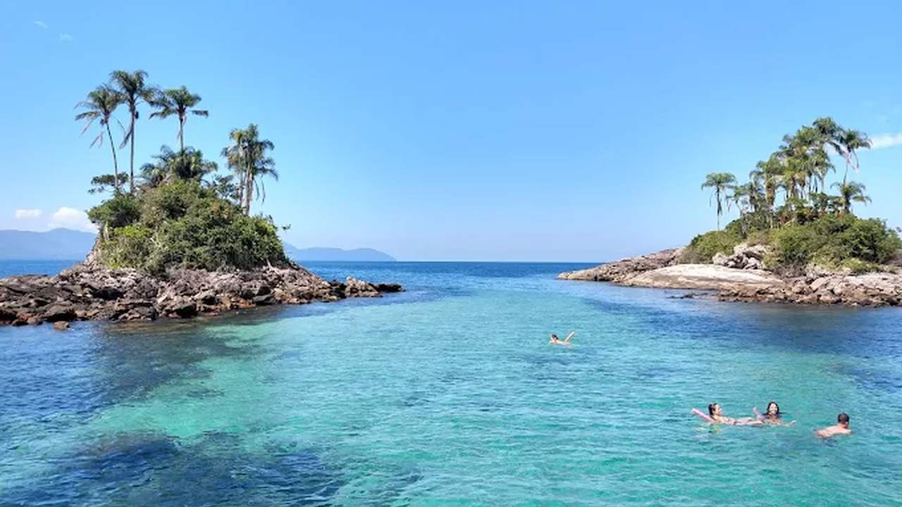 Ilhas Botinas com mar azul turquesa e pessoas nadando, foto de Vera Bordignon