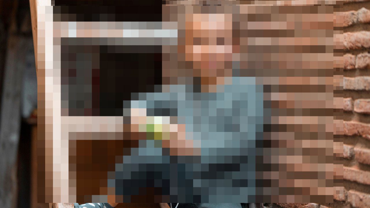 Imagem borrada de pessoa em um ambiente interno, possivelmente um abrigo.