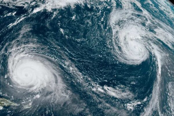 Imagem de satélite mostra dois ciclones sobre o oceano, com o Estado do Rio de Janeiro visível.