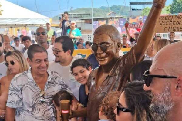 Inauguração da estátua de Zeca Pagodinho em Xerém, com multidão e homenagens.