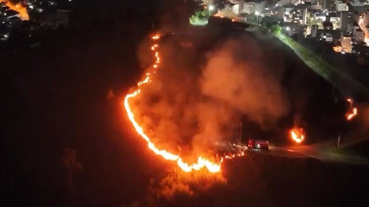 Incêndio florestal no bairro Suíço em Nova Friburgo, RJ, à noite.