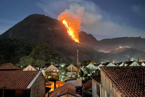 Incêndio na Pedra do Imperador em Nova Friburgo durante a noite, com fogo intenso na encosta da montanha.