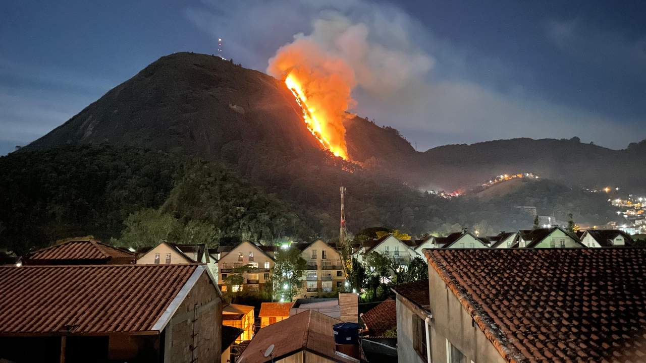 Incêndio na Pedra do Imperador em Nova Friburgo durante a noite, com fogo intenso na encosta da montanha.