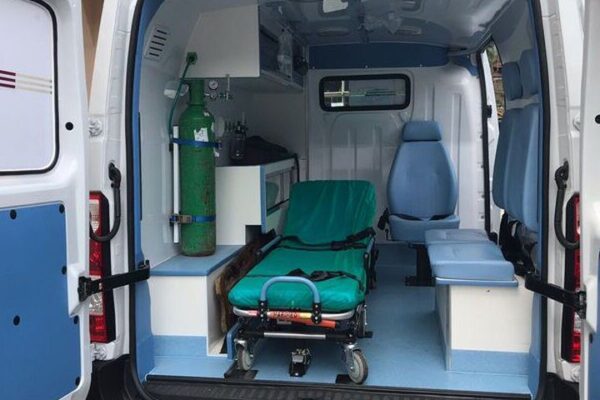 Interior de ambulância, com maca, assentos e equipamento médico, provavelmente em Lumiar.