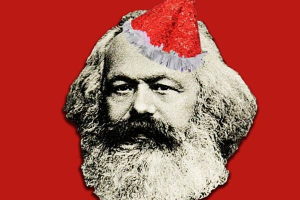 Karl Marx com chapéu de Papai Noel em fundo vermelho