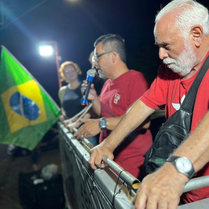 Manifestação em Nova Friburgo em apoio à democracia, com bandeira do Brasil e pessoas falando.