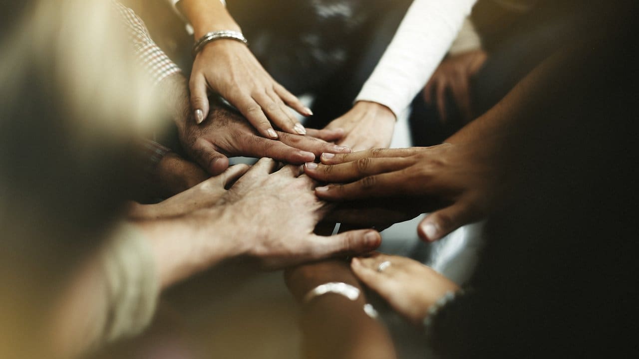 Mãos unidas em sinal de união e acordo, representando negociação salarial.