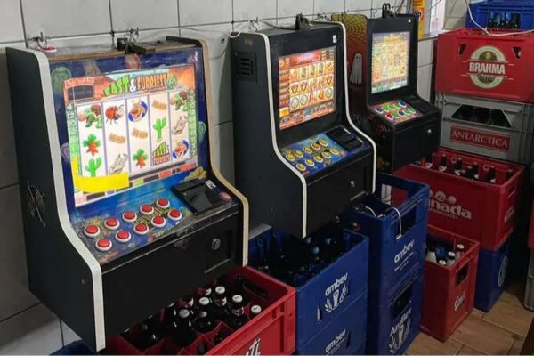 Máquinas caça-níqueis em bar, possivelmente relacionadas a investigação de jogos ilegais.