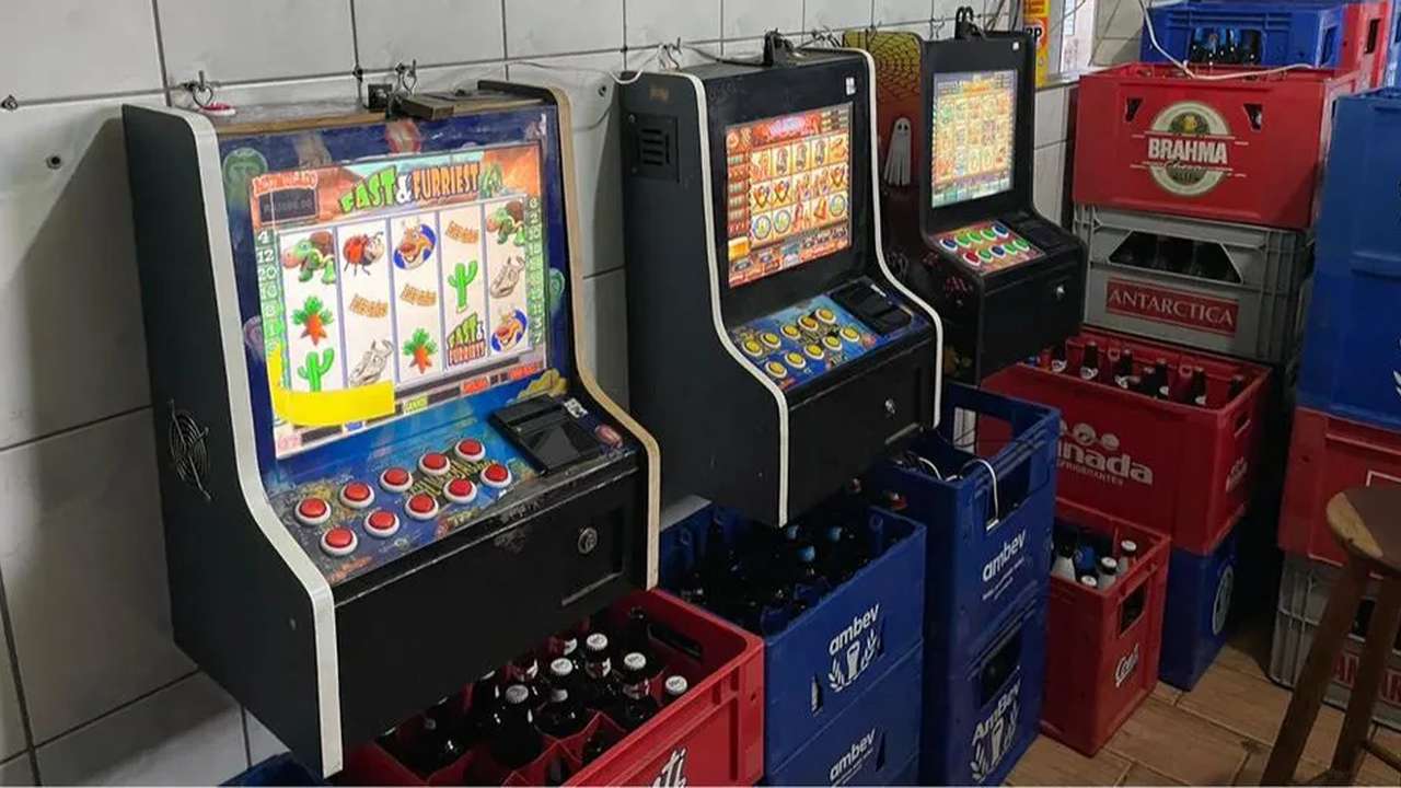 Máquinas caça-níqueis em bar, possivelmente relacionadas a investigação de jogos ilegais.
