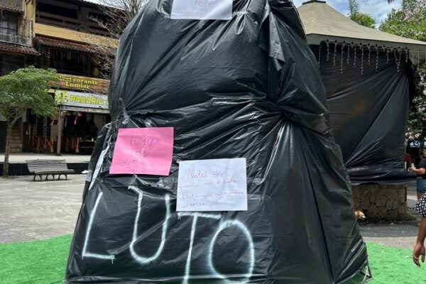 Monumento coberto com plástico preto e mensagens de luto e socorro em Lumiar.