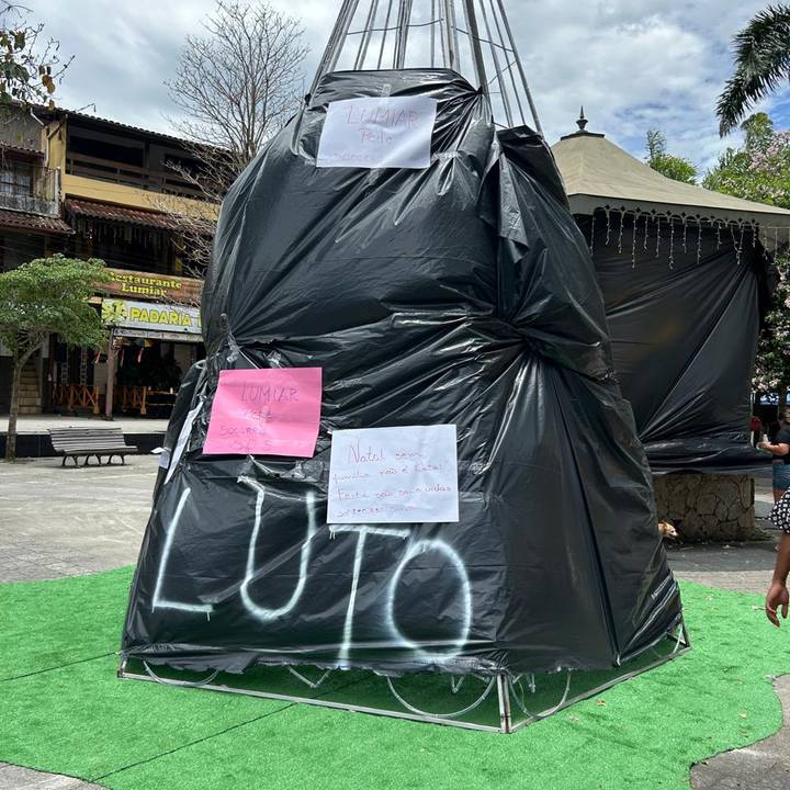 Monumento coberto com plástico preto e mensagens de luto e socorro em Lumiar.