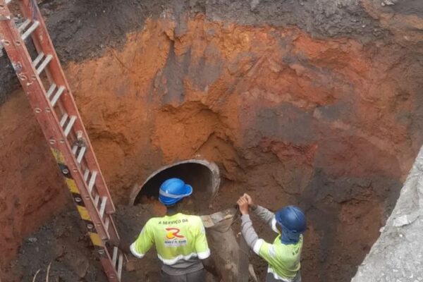 Obras de emergência em rodovia no Rio de Janeiro, com trabalhadores e escavação.
